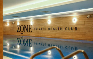 ZONE Private Health Club - Bazen ZONE Private Health Club nudi prelivni bazen impresivnih dimenzija: dužina 23m, širina 7m i dubina 160cm. Filtraciji vode u bazenu je dat veliki znacaj. Kompletna zapremina vode u bazenu isfiltrira se za 3,3 casa,uz minimalne utroske hemikalija koje obezbedjuju bakteriolosku sigurnost vode. Voda u bazenu je uvek u okvirima prijatne temperature 27–29°C čineći ga idealnim za sve koji žele da se rekreiraju ili profesionalno plivaju. Za potpuni doživljaj komfora pored bazena su dodate i udobne ležaljke i fotelje.